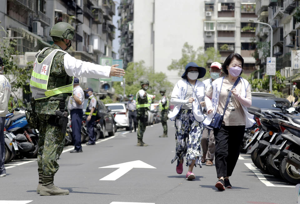 FILE - People are guided by Taiwanese soldiers to a basement shelter during the Wanan air raid drill in Taipei, Taiwan, on July 25, 2022. Taiwan’s government is racing to counter China’s military, but many on the island say they don’t share the sense of threat. (AP Photo/Chiang Ying-ying, File)