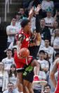 Ohio State's Musa Jallow, left, dishes off against Michigan State's Kenny Goins during the first half of an NCAA college basketball game, Sunday, Feb. 17, 2019, in East Lansing, Mich. (AP Photo/Al Goldis)