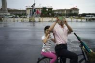 Onlookers take photographs near to an area where access has been blocked to the public in Tiananmen Square in China's capital Beijing on September 1, 2015