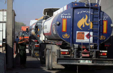 A member of Palestinian security forces gestures as a fuel tanker arrives at Kerem Shalom crossing in Rafah in the southern Gaza Strip August 15, 2018. REUTERS/Ibraheem Abu Mustafa