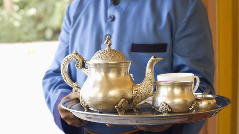 Man carrying tea set on tray