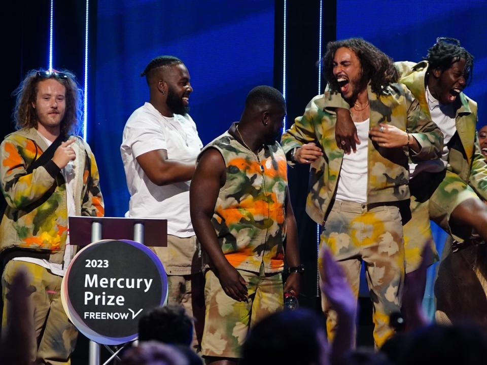 The group celebrate on stage after winning the 2023 Mercury Prize award (PA)