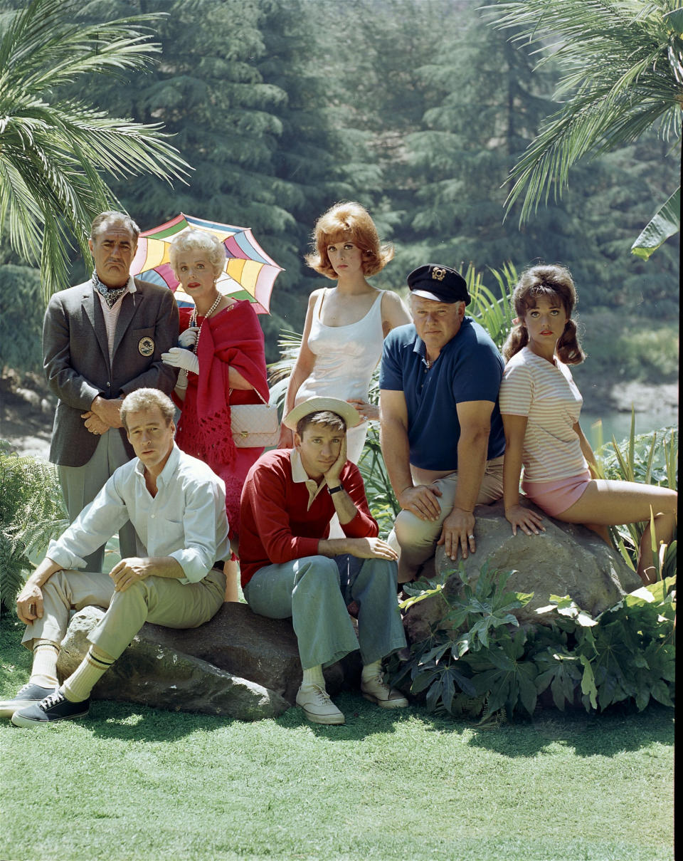 Portrait of the cast of 'Gilligan's Island,' 1964. Back row, from left, American actors Jim Backus (1913 - 1989) as Thurston Howell III, Natalie Schafer (1900 - 1991) as Mrs. Howell, Tina Louise as Ginger Grant, Alan Hale Jr. (1918 - 1990) as the Skipper, and Dawn Wells as Mary Ann Summers; front row, from left, Russell Johnson as the Professor and Bob Denver as Gilligan. (Photo by CBS Photo Archive/Getty Images)