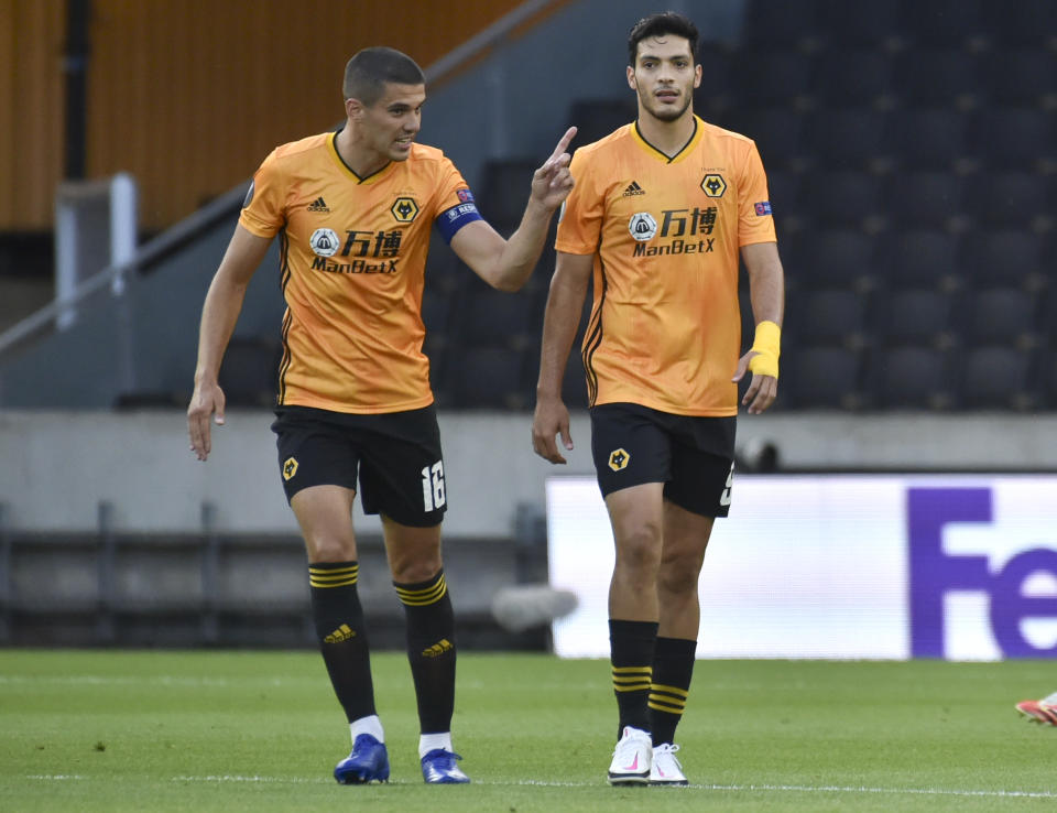 Wolverhampton Wanderers' Raul Jimenez, right, talks with his captain Conor Coady after scoring his team's first goal from the penalty spot during the Europa League round of 16 second leg soccer match between Wolves and Olympiakos at Molineux Stadium in Wolverhampton, England, Thursday, Aug. 6, 2020. (AP Photo/Rui Vieira)