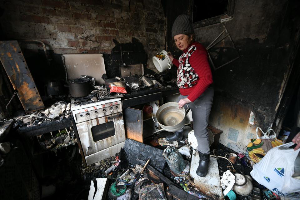 Residents and relatives carry belongings out of their burned out flat in Donetsk (AFP via Getty Images)