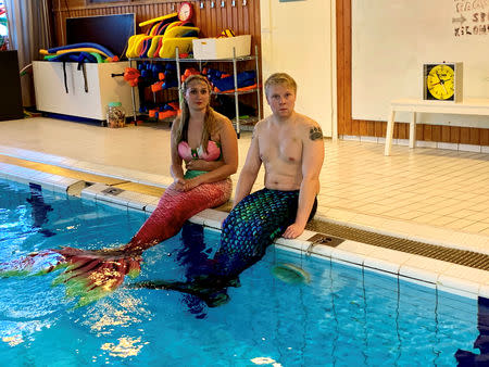 Wellness expert Maija Mottonen and her student Markus Parviainen with their mermaid tails pose for a picture in the pool in Espoo, Finland January 11, 2019. Picture taken January 11, 2019. REUTERS/Attila Cser