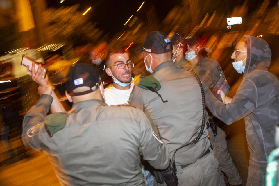 Israeli border police men push away a right-wing protester from a protest against Israeli Prime Minister Benjamin Netanyahu in Jerusalem, Thursday, July 30, 2020. (AP Photo/Ariel Schalit)