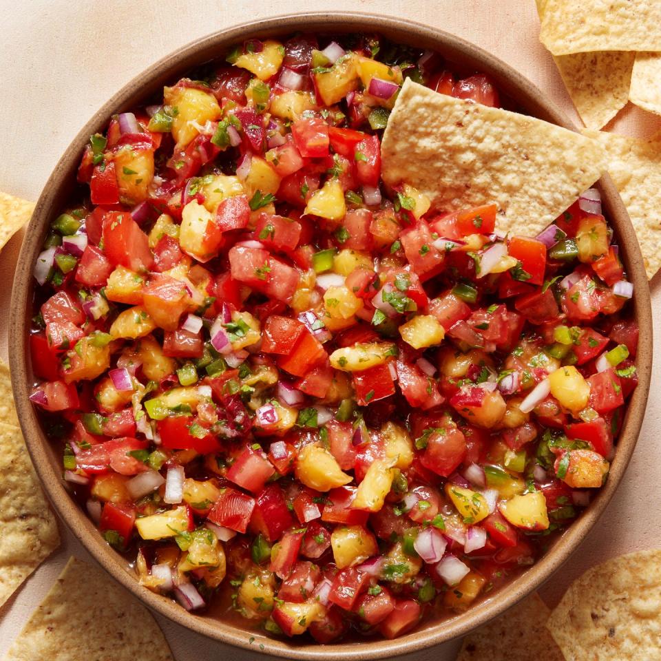 finely chopped peaches and tomatoes in a bowl with tortilla chips