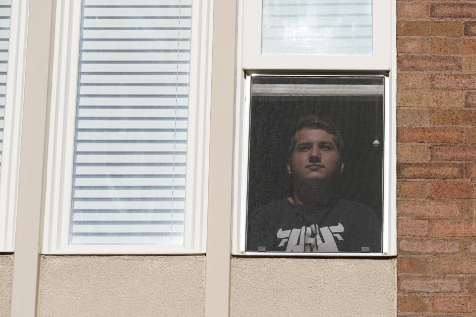 Ryan Schmutz looks from his dorm at Utah State University Wednesday, Sept. 2, 2020, in Logan, Utah. Schmutz was one of about 300 students quarantined to their rooms this week, but not because anyone got sick or tested positive. Instead, the warning bells came from the sewage. Colleges around the country are monitoring wastewater in hopes of stopping coronavirus outbreaks before they get out of hand. Utah State became at least the second school to quarantine hundreds of students after sewage tests detected the virus. (AP Photo/Rick Bowmer)