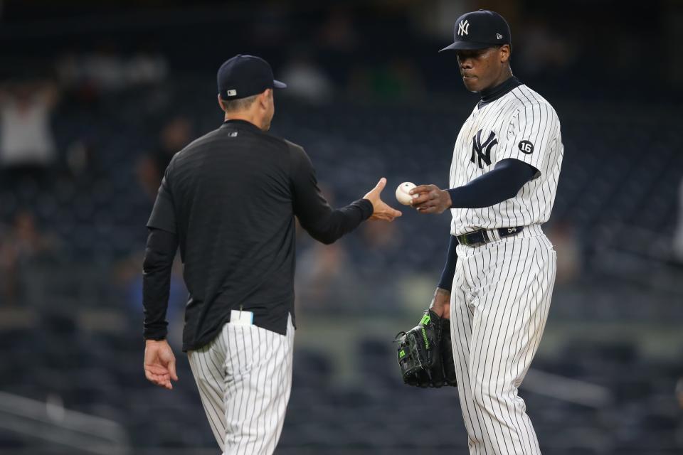 Yankees manager Aaron Boone (left) takes relief pitcher Aroldis Chapman (right) out of the game against the Los Angeles Angels during the ninth inning at Yankee Stadium.