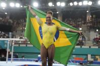 La brasileña Rebeca Andrade se arropa con su bandera nacional tras ganar la medalla de oro en el salto con potro de los Juegos Panamericanos en Santiago, Chile, el martes 24 de octubre de 2023. (AP Foto/Martín Mejía)