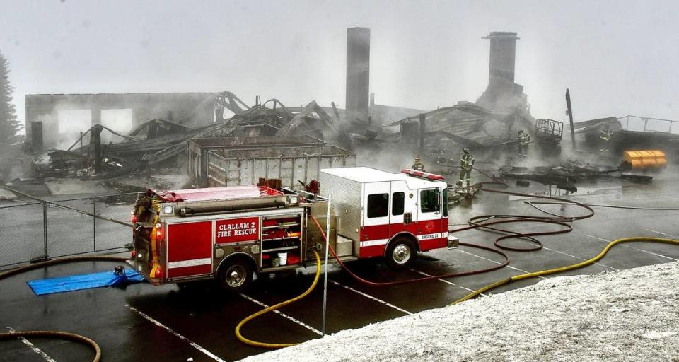 Clallam County Fire District 2 and the smoldering remains of the Hurricane Ridge day lodge. The Olympic National Park lodge was destroyed by fire Sunday while it was closed for renovations. The lodge was due to reopen Memorial Day weekend.