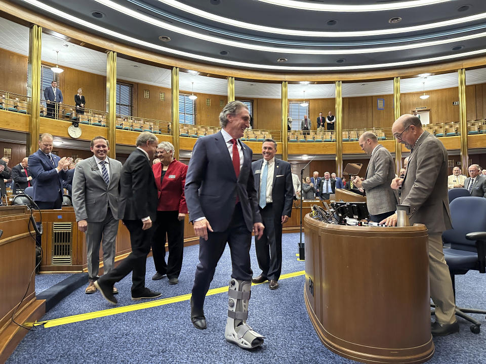 North Dakota Republican Gov. Doug Burgum, center, walks to the rostrum in the state House of Representatives before his State of the State speech Monday, Oct. 23, 2023, at the state Capitol in Bismarck, N.D. Four legislative leaders escorted him through the chamber, Democratic House Minority Leader Zac Ista, from left, Republican House Majority Leader Mike Lefor, Democratic Senate Minority Leader Kathy Hogan and Republican Senate Majority Leader David Hogue. The state's Republican-controlled Legislature convened in a special session primarily to address a major budget bill struck down last month by the state Supreme Court. (AP Photo/Jack Dura)