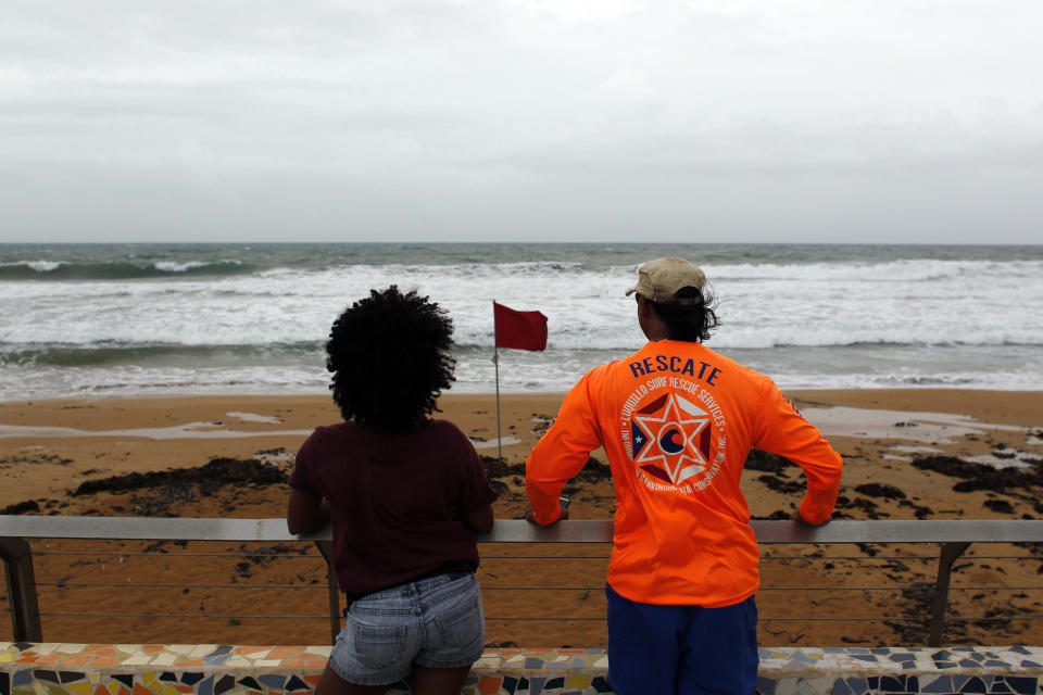 <p>A couple watch from the shore at heavy surf as hurricane Irma approaches Puerto Rico in Luquillo, on Sept. 6, 2017. (Photo: Ricardo Arduengo/AFP/Getty Images) </p>