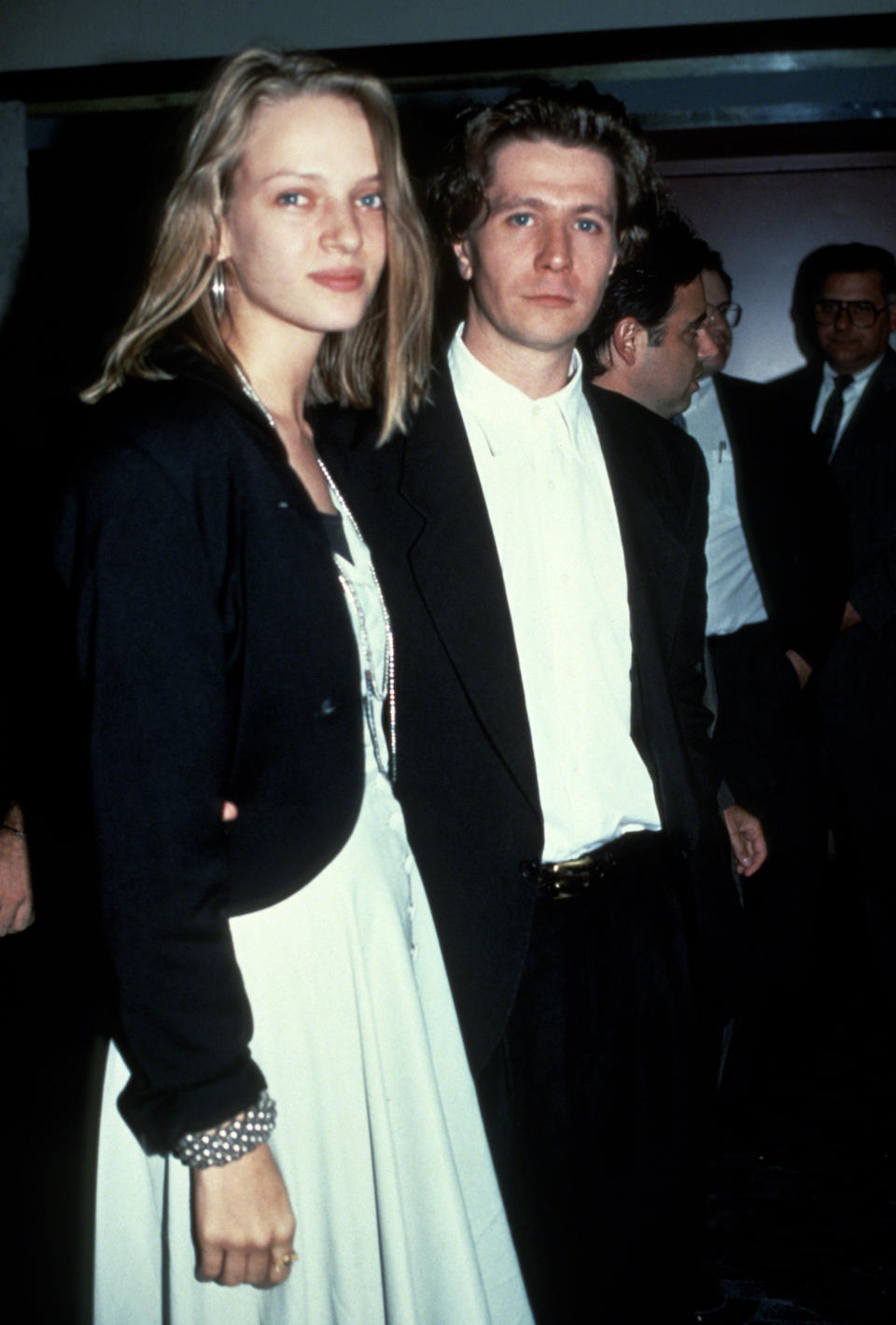 Uma Thurman in a white dress with a black jacket and Andrew McCarthy in a black suit and a white shirt
