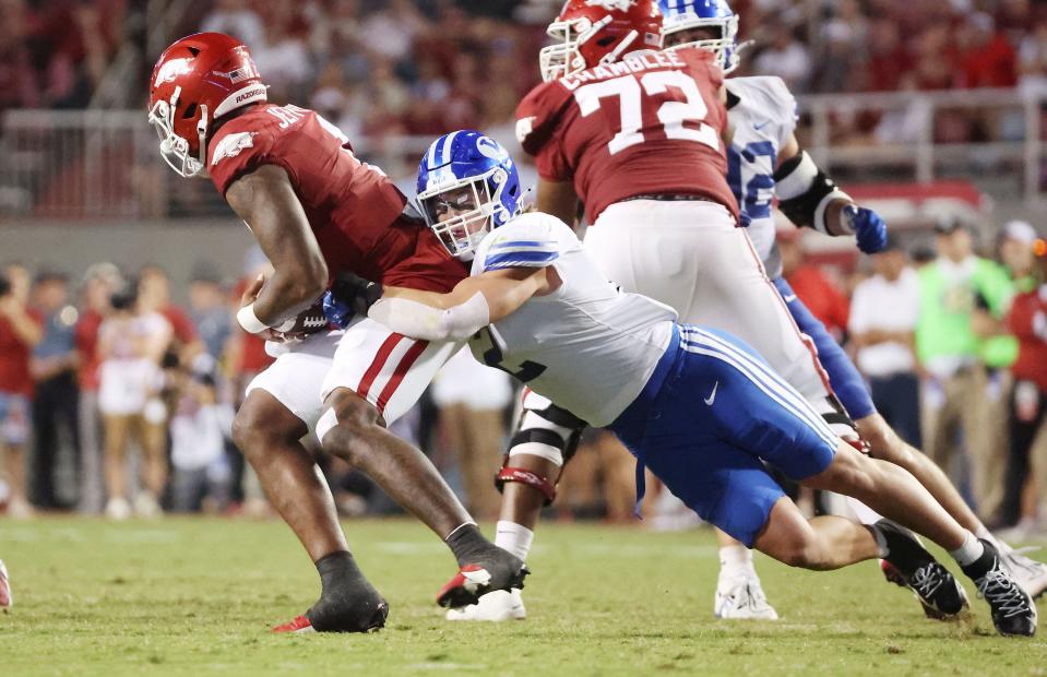 Brigham Young Cougars linebacker Ben Bywater (2) tries to sack Arkansas Razorbacks quarterback KJ Jefferson (1) at Razorback Stadium in Fayetteville on Saturday, Sept. 16, 2023. BYU won 38-31.