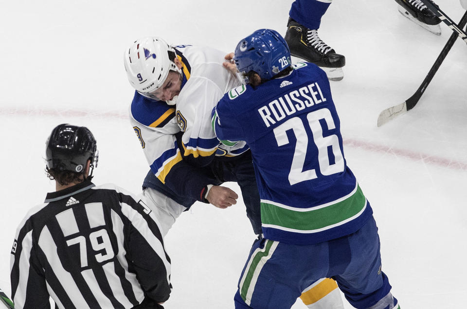 Vancouver Canucks' Antoine Roussel (26) and St. Louis Blues' Sammy Blais (9) fight during the first period of an NHL Western Conference Stanley Cup playoff game in Edmonton, Alberta, Monday, Aug. 17, 2020. (Jason Franson/The Canadian Press via AP)