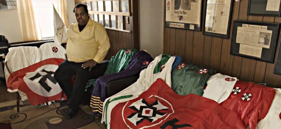 Daryl Davis and Ku Klux Klan robes and Nazi flag
