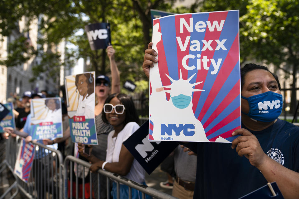 Spectators wait along Broadway as marchers pass through the Financial District during a parade honoring essential workers for their efforts in getting New York City through the COVID-19 pandemic, Wednesday, July 7, 2021, in New York. The parade kicked off at Battery Park and travel up Broadway in lower Manhattan, the iconic stretch known as the Canyon of Heroes, which has hosted parades honoring world leaders, celebrities and winning sports teams. (AP Photo/John Minchillo)