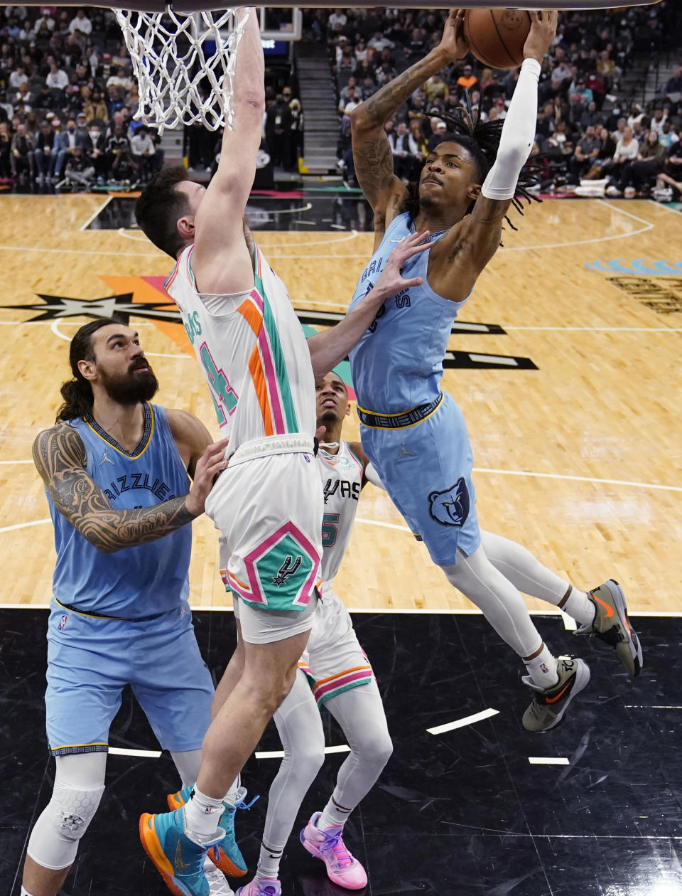 Memphis Grizzlies guard Ja Morant (12) drives to the basket against San Antonio Spurs forward Drew Eubanks (14) during the second half of an NBA basketball game, Wednesday, Jan. 26, 2022, in San Antonio. (AP Photo/Eric Gay)