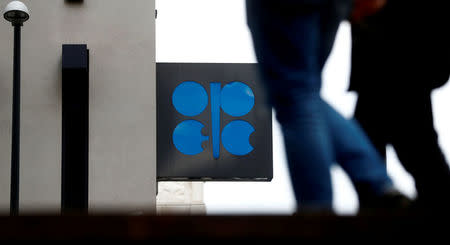 FILE PHOTO: People walk past the logo of the Organization of the Petroleum Exporting Countries (OPEC) in front of its headquarters in Vienna, Austria September 21, 2017. REUTERS/Leonhard Foeger/File Photo