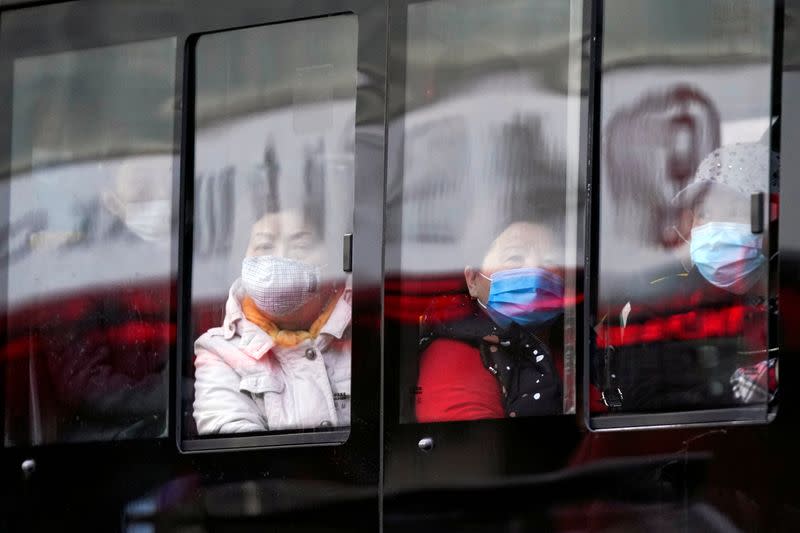 People wear protective face masks on a bus following an outbreak of coronavirus disease (COVID-19), in downtown Shanghai