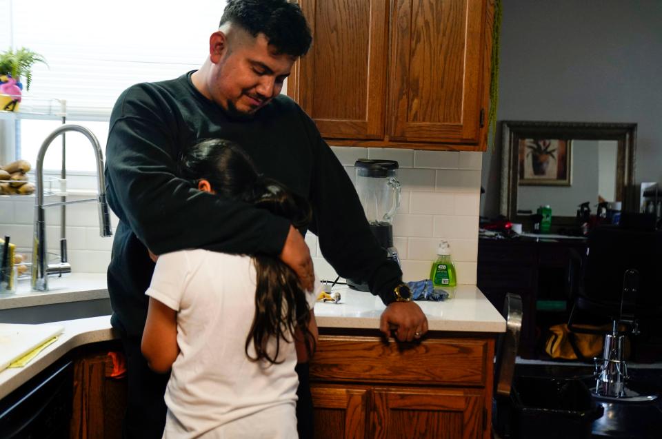 Daniel Paz hugs Angie as she begins to cry after recalling memories of being separated from her father after crossing the southern border. The pair were separated for months, and years later Angie continues to suffer trauma from the separation.