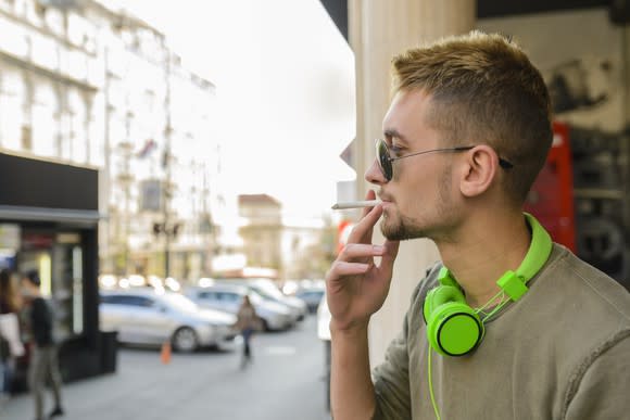 Man with green headphones smoking cigarette