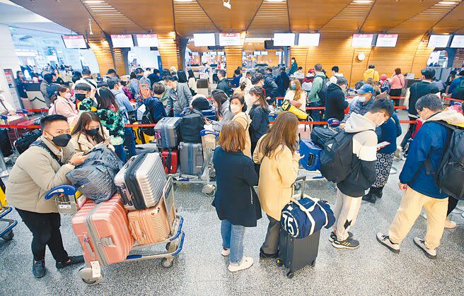 桃園機場28日預估客運量約為84799人次，是春節期間的最高峰。圖為大批旅客在第一航廈內排隊辦理登機手續。（范揚光攝）
