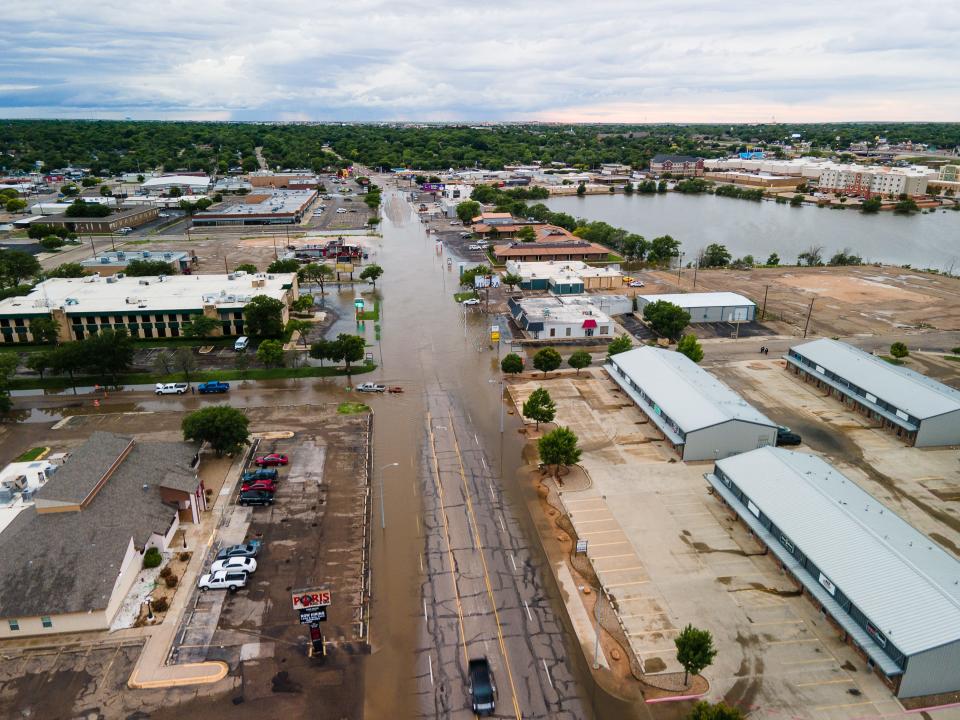 Lawrence Lake (also known as Dunivan Lake) floods over its banks into the streets, leading to closures Friday during flash flooding in Amarillo.