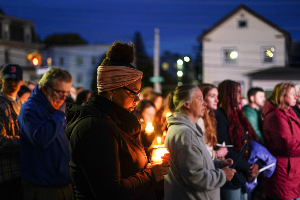 People hold candles while gathering outside for a vigil (Matt Rourke / AP)
