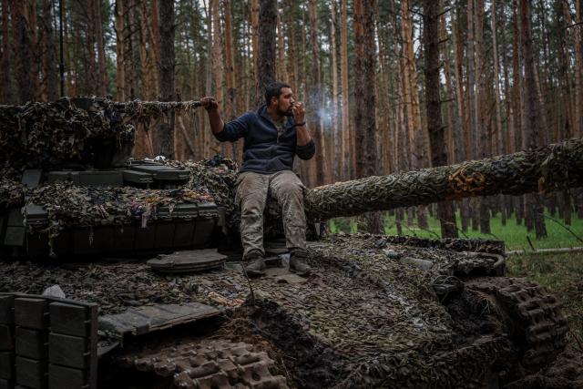 A Ukrainian tank serviceman smokes a cigarette on his tank (AFP via Getty Images)