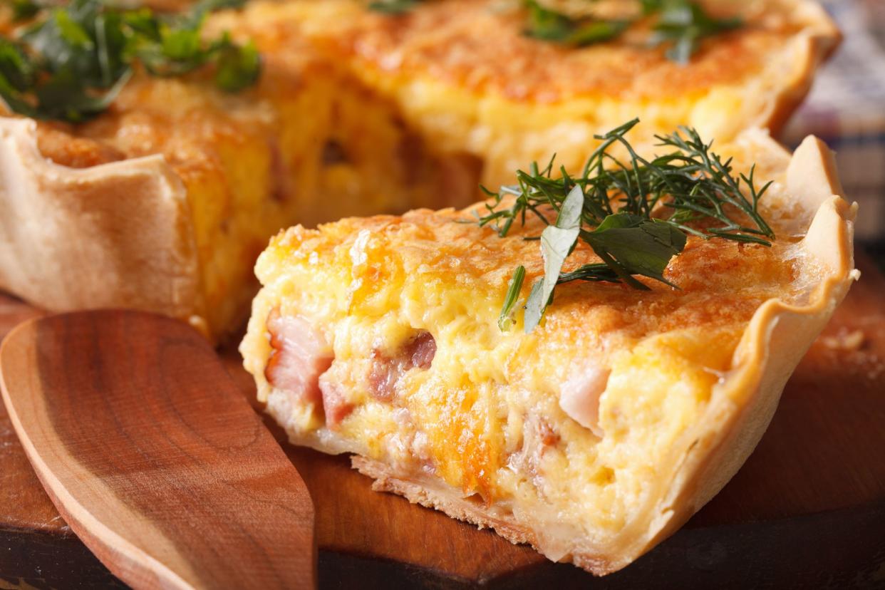 A piece of French quiche Lorraine on the cutting board macro. horizontal