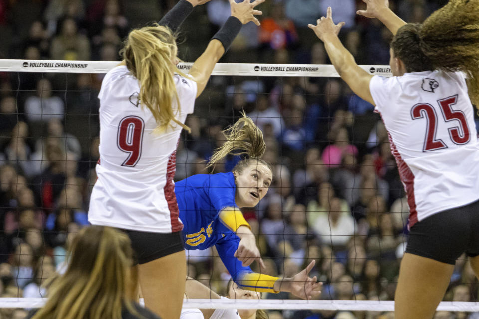 Pittsburgh's Rachel Fairbanks (10) spikes the ball against Louisville's Claire Chaussee (9) and Amaya Tillman (25) during the semifinals of the NCAA volleyball tournament, Thursday, Dec. 15, 2022 in Omaha, Neb. (AP Photo/John S. Peterson)