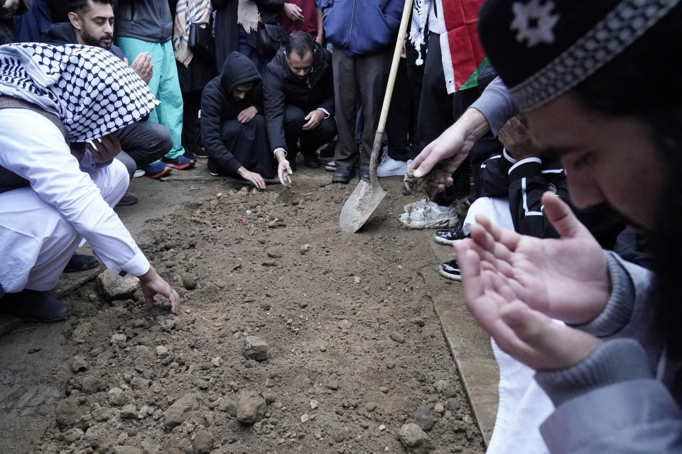 FILE - Muslim community members mourn Wadea Al Fayoume at his grave in LaGrange, Ill., Oct. 16, 2023. A Palestinian-American woman seriously injured in a suspected hate crime that left her 6-year-old son dead in a suburb of Chicago is asking the public to “pray for peace” as she recuperates from her injuries. Hanaan Shahin issued a statement Tuesday, Oct. 24, 2023 through the Chicago chapter of the Council on American-Islamic Relations after meeting with the group’s executive director a day earlier. It marked her first public comments since the brutal Oct. 14 attack that left her with multiple stab wounds and stitches on her face. (AP Photo/Nam Y. Huh, file)