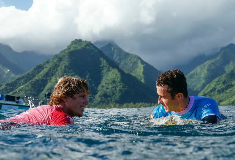 Alan Cleland Quinonez (izq.), de México, conversa con Andy Criere, de España, después de la sexta serie de la ronda 2 del surf masculino, en Teahupo'o, en la isla polinesia francesa de Tahití