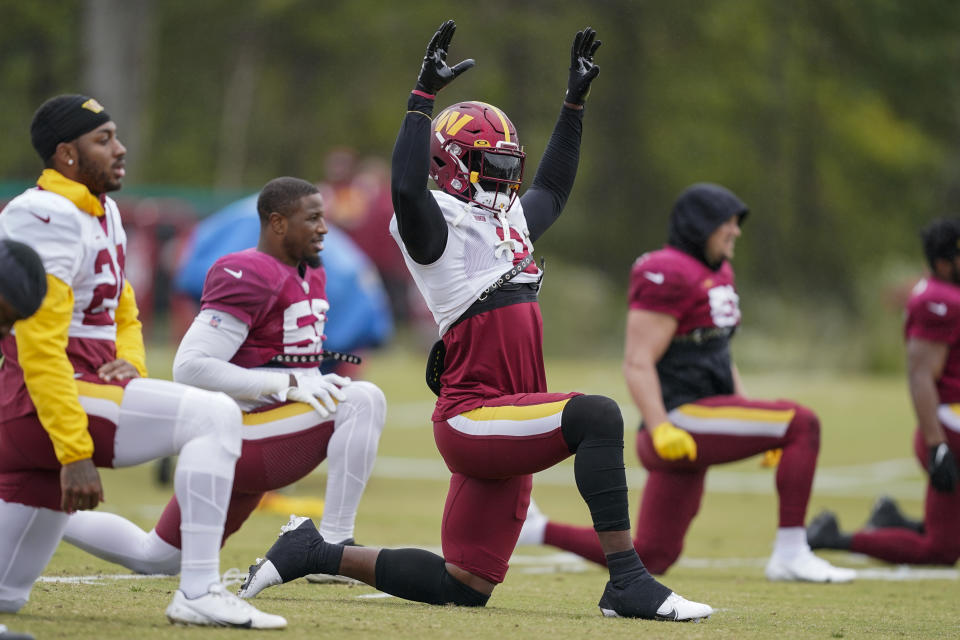 Washington Commanders running back Brian Robinson Jr., center, warms up during practice at the team's NFL football training facility, Wednesday, Oct. 5, 2022, in Ashburn, Va. Robinson was shot twice in the right leg Aug. 28 in Washington, was taken to a hospital, underwent surgery and was released a day later. The bullets missed all the major ligaments and bones in his knee. (AP Photo/Alex Brandon)