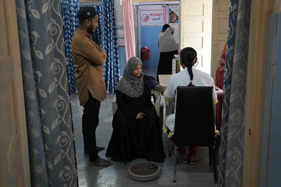 A nurse checks the blood pressure of Shireen Fatima, who is four months pregnant, during her routine checkup at Zaheerabad health care center which runs on rooftop solar power, in Raichur, India, Wednesday, April 19, 2023. In semi-urban and rural regions of India and other developing countries with unreliable power grids, decentralized renewable energy — especially solar — is making all the difference in delivering modern health care. (AP Photo/Aijaz Rahi)