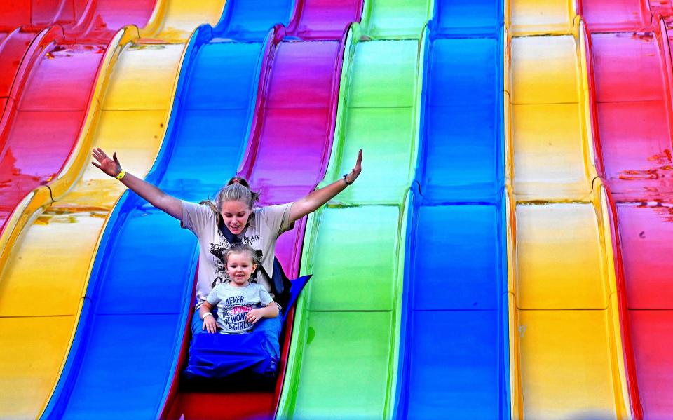 Kate and Madeline Mayo enjoy a ride down the slide during the 2018 Wilson County Fair on Aug. 17, 2018, in Lebanon.