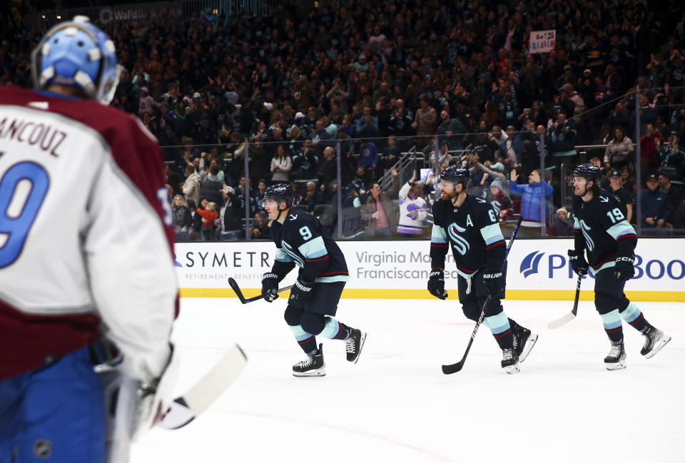 Seattle Kraken center Ryan Donato (9) and teammates Adam Larsson (6) and Jared McCann (19) head to the bench after Donato scored against Colorado Avalanche goaltender Pavel Francouz, foreground, during the second period of an NHL hockey gam Saturday, Jan. 21, 2023, in Seattle. (AP Photo/Lindsey Wasson)