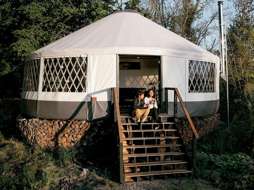 Zach Both and his girlfriend sitting on the stairs of their yurt