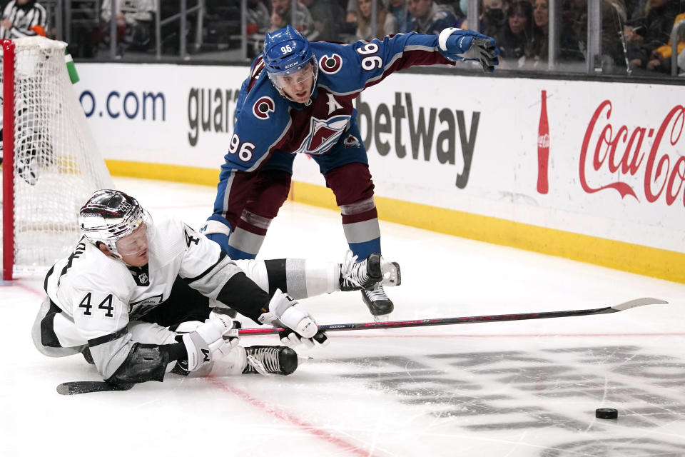 Los Angeles Kings defenseman Mikey Anderson, left, falls as he tries to pass the puck while under pressure from Colorado Avalanche right wing Mikko Rantanen during the third period of an NHL hockey game Thursday, Jan. 20, 2022, in Los Angeles. (AP Photo/Mark J. Terrill)