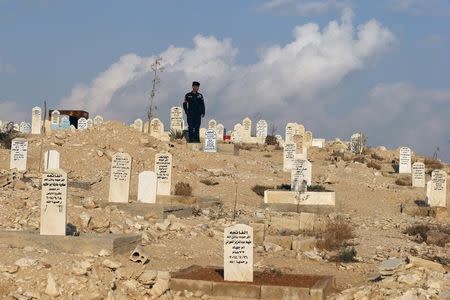 A member of the police attends the funeral of Kamal Milkawi, the one of the Jordanians who killed in a shooting incident, in Zarqa, Jordan, November 10, 2015. REUTERS/Muhammad Hamed