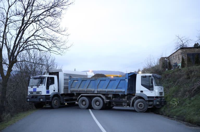Camiones utilizados como barricada se ven en la carretera cerca de la aldea de Rudare, norte de Kosovo, sábado, 10 de diciembre de 2022. Kosovo ha pospuesto las elecciones locales que debían celebrarse el 10 de diciembre.