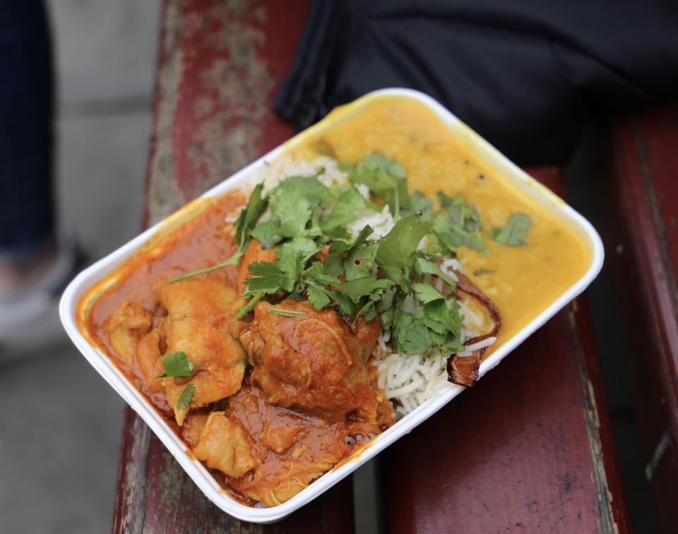 Freshly made curry and rice in a cardboard takeaway container sold at Manchester Christmas markets.