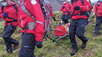 Volunteers from Wasdale mountain rescue team carry 121lb (55kg) St Bernard dog, Daisy from England's highest peak, Scafell Pike, Sunday July 26, 2020. The mountain rescue team spent nearly five hours rescuing St Bernard dog Daisy, who had collapsed displaying signs of pain in her rear legs and was refusing to move, while descending Scafell Pike. The Wasdale Mountain Rescue team rely on public contributions to their JustGiving.com/wasdalemrt page to fund their mountain safety efforts. (Wasdale Mountain Rescue via AP)