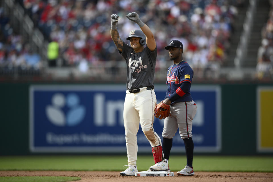 Washington Nationals' Nick Senzel, front, reacts at second base after he doubled in a run during the fourth inning of a baseball game, Saturday, June 8, 2024, in Washington. Atlanta Braves second baseman Ozzie Albies watches at back. (AP Photo/Nick Wass)