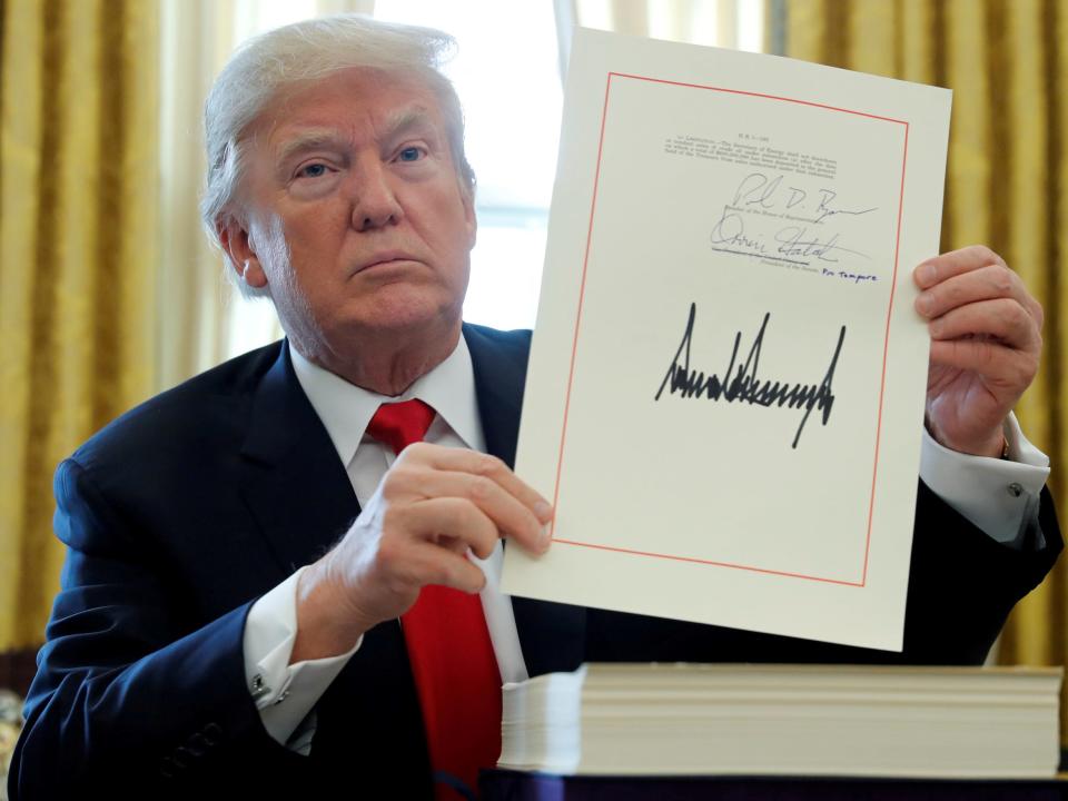 Donald Trump displays his signature after signing the $1.5 trillion tax overhaul plan in 2017
