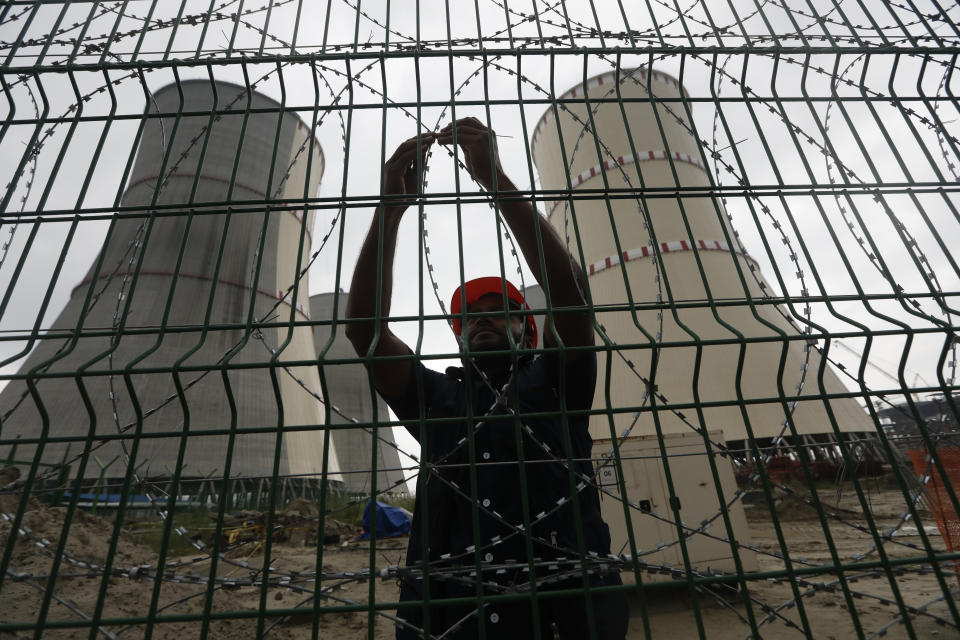 A man fixes a barbed wire on the fence of the Rooppur Nuclear Power Plant at Ishwardi in Pabna, Bangladesh, Wednesday, Oct.4, 2023. (AP Photo/Mahmud Hossain Opu)