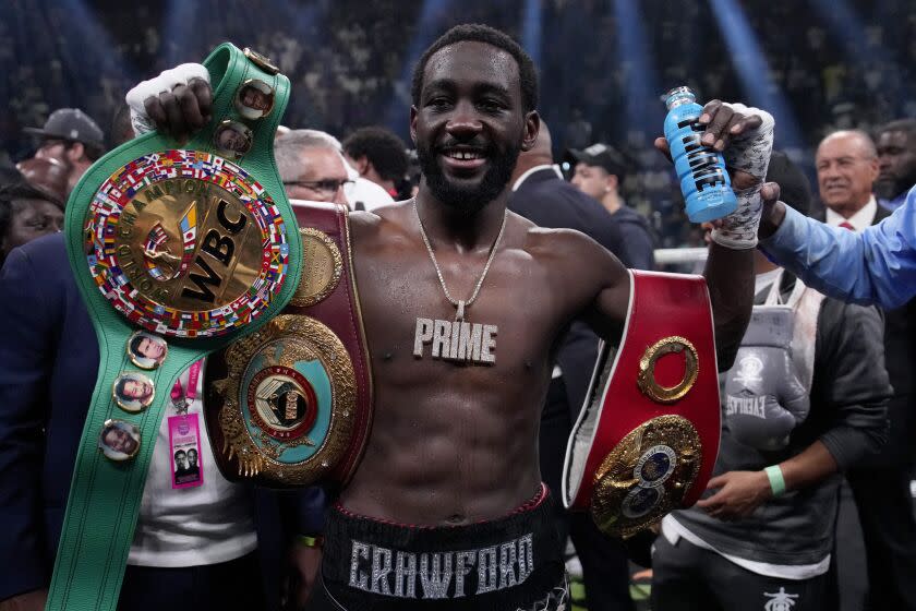 Boxer holds up championship belts